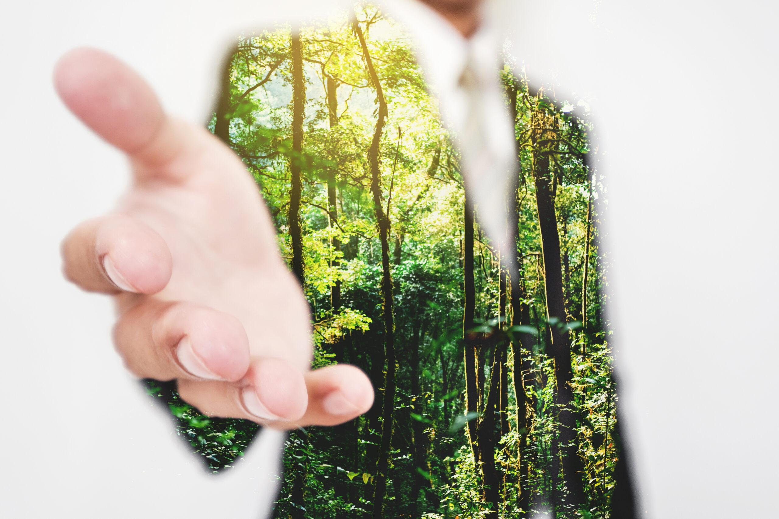 Double,Exposure,,Businessman,Stretching,Hand,To,Hand,Shake,With,Green